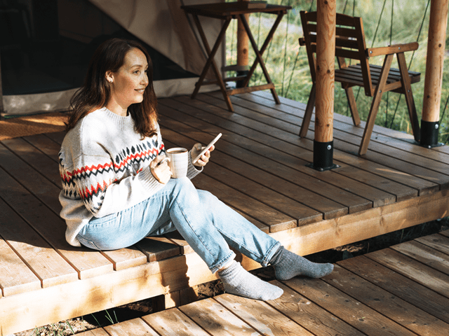 Kvinne med kaffekopp og telefon