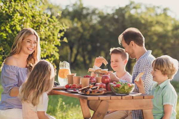 Famile som sitter ut og spiser frokost
