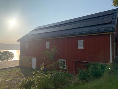 Bilde om grønt landbrukslån, fjøs med solcelle på taket.