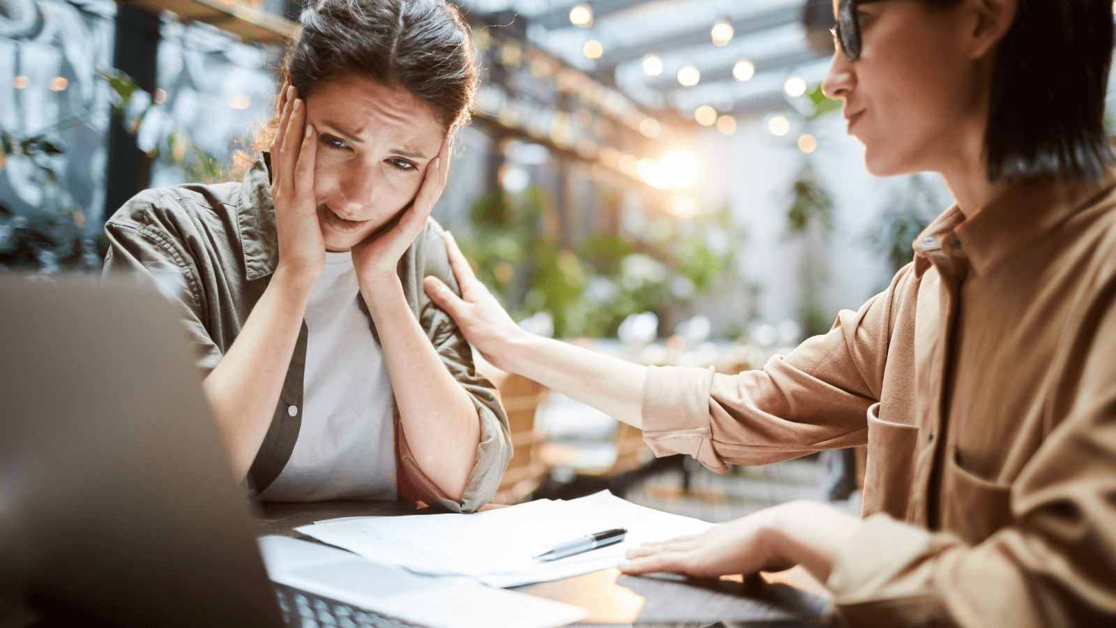 Frustrert kvinne som får klapp på skulder av annen kvinne