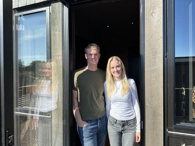Erik og Miriam som står i verandadøren på sin nye minibolig.