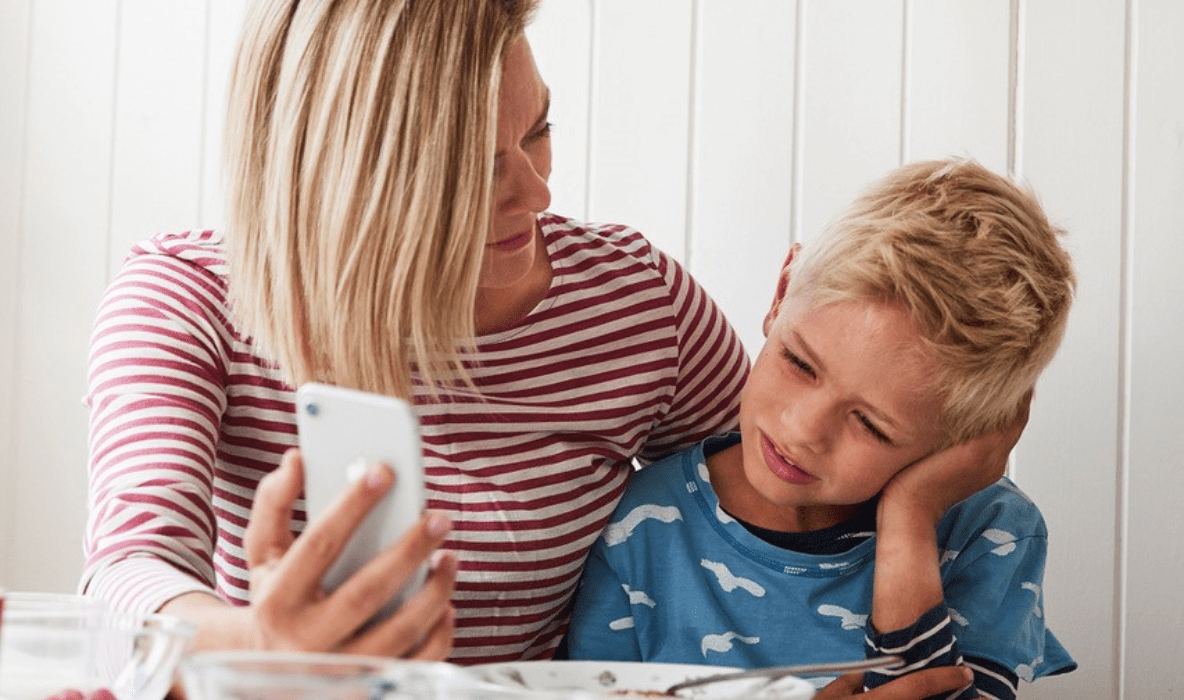 Sykt barn sammen med mammaen sin som snakker med Eyr på mobil.